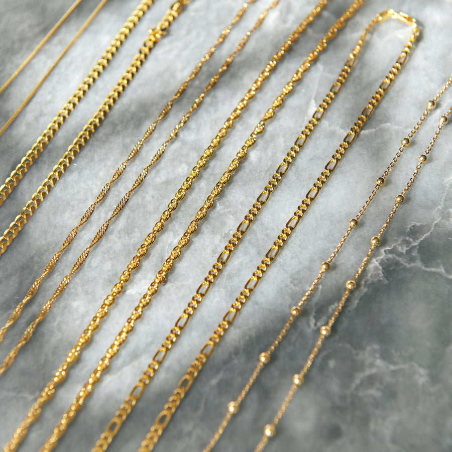 18 karat gold vermeil chains marble flat lay